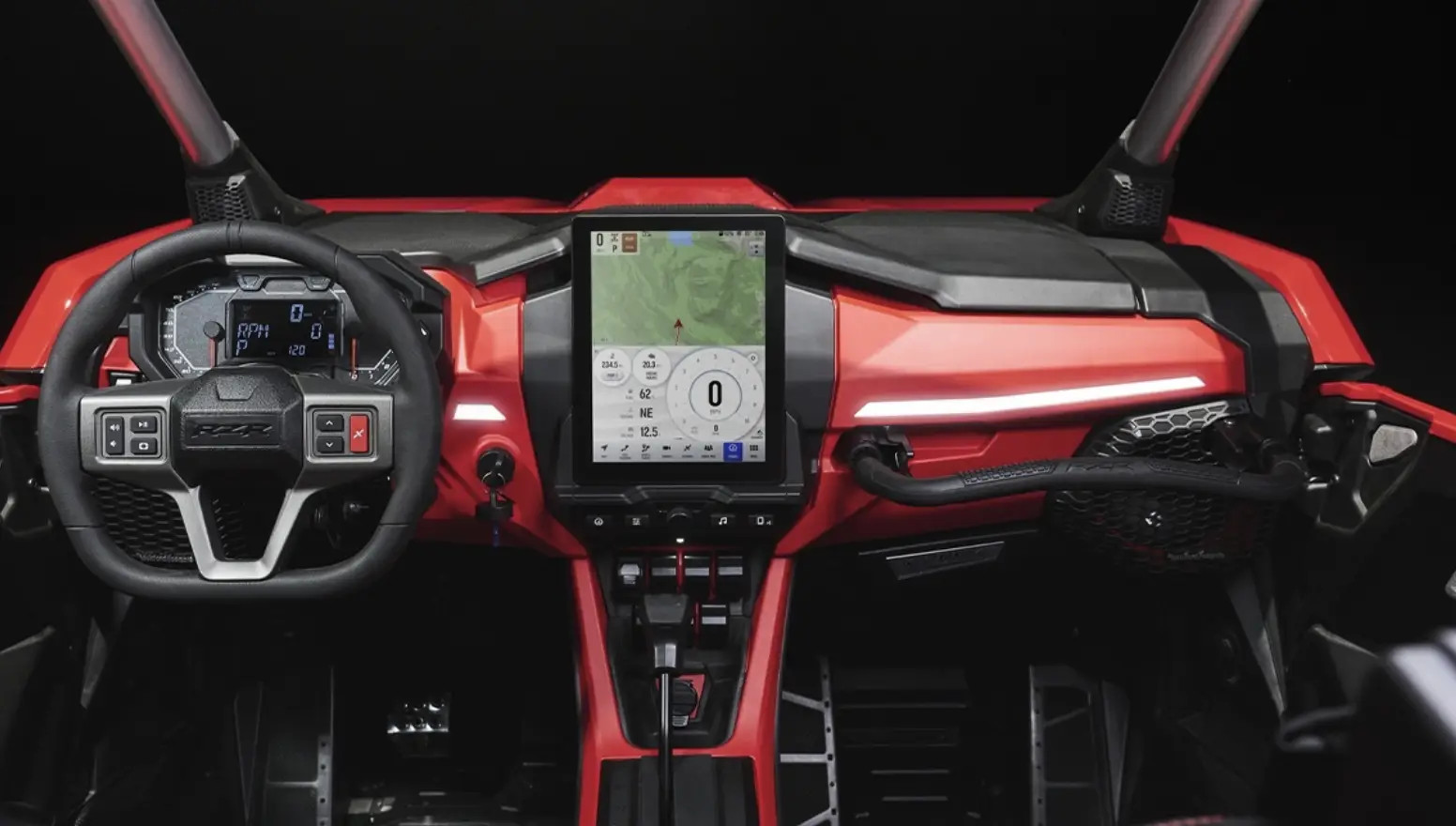 Dashboard and steering wheel of a red off-road vehicle with a central touchscreen displaying GPS navigation and vehicle data.