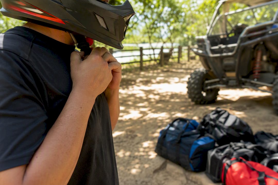 Driver adjusting UTV helmet strap