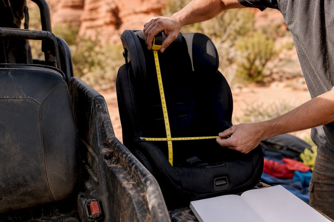 Hands measuring child car seat and UTV seat