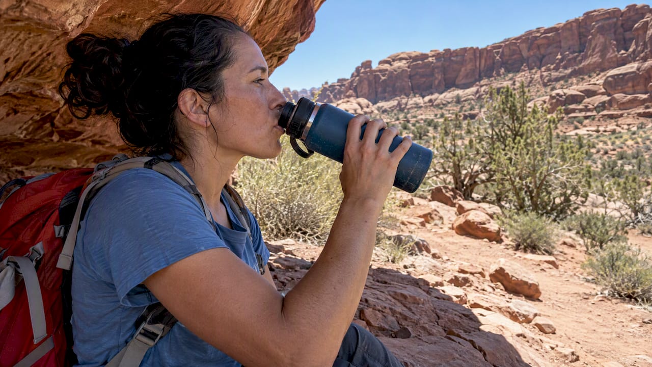 Visitor drinking water at a Moab trail pullout