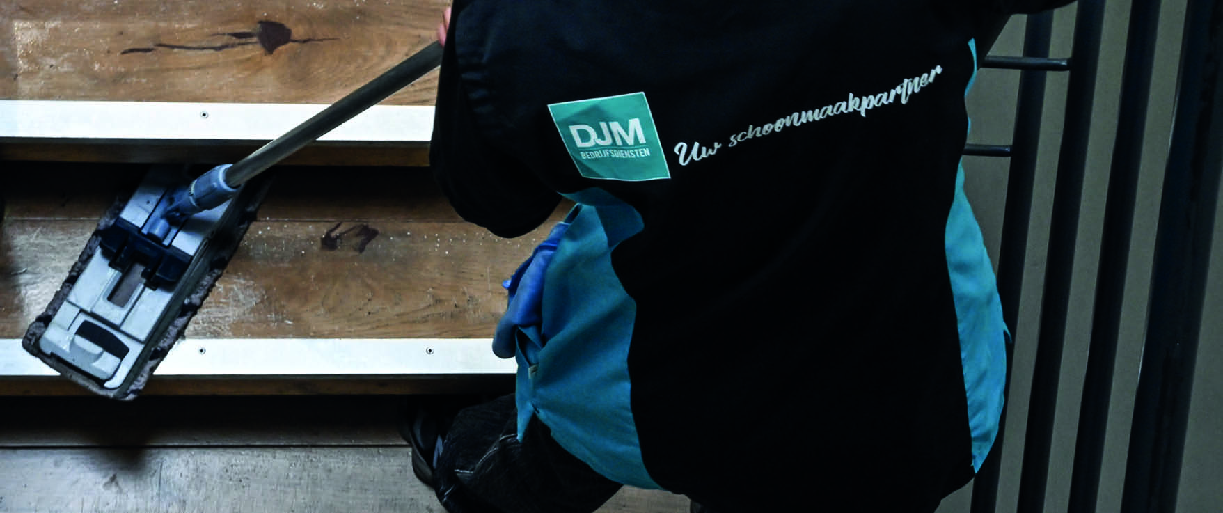 Professionele schoonmaakkar van DJM Bedrijfsdiensten met sprayflessen, doeken en afvalbakken met kleurcodering.