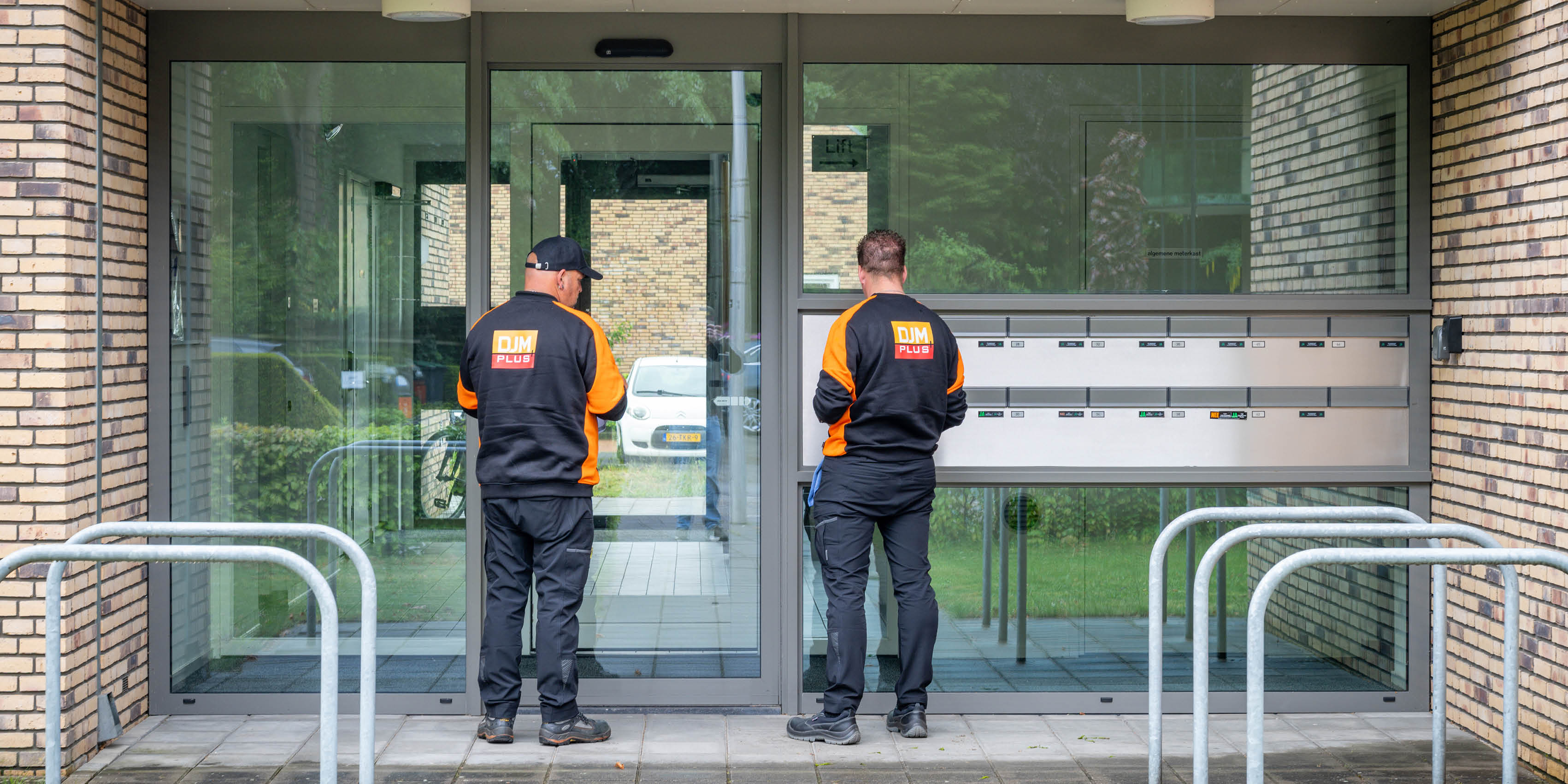Professionele vloerreinigingsmachine die met stoom en roterende borstels een gang schoonmaakt in een gebouw.