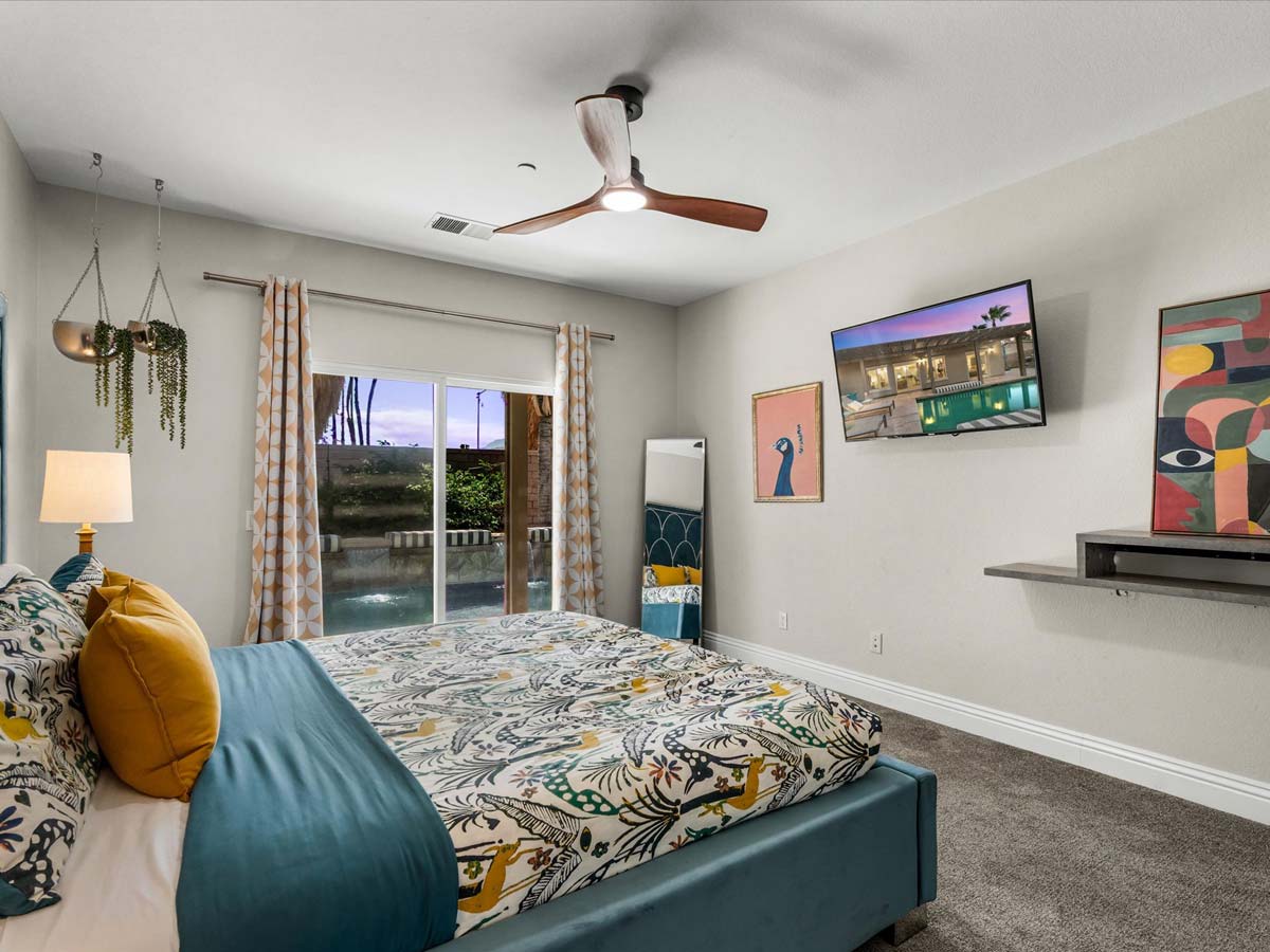 secondary bedroom with queen bed and patio access tropical villa palm springs