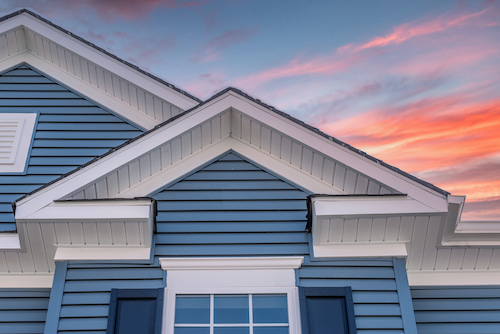 Residential home with blue siding and white trim, showcasing modern exterior siding installation.
