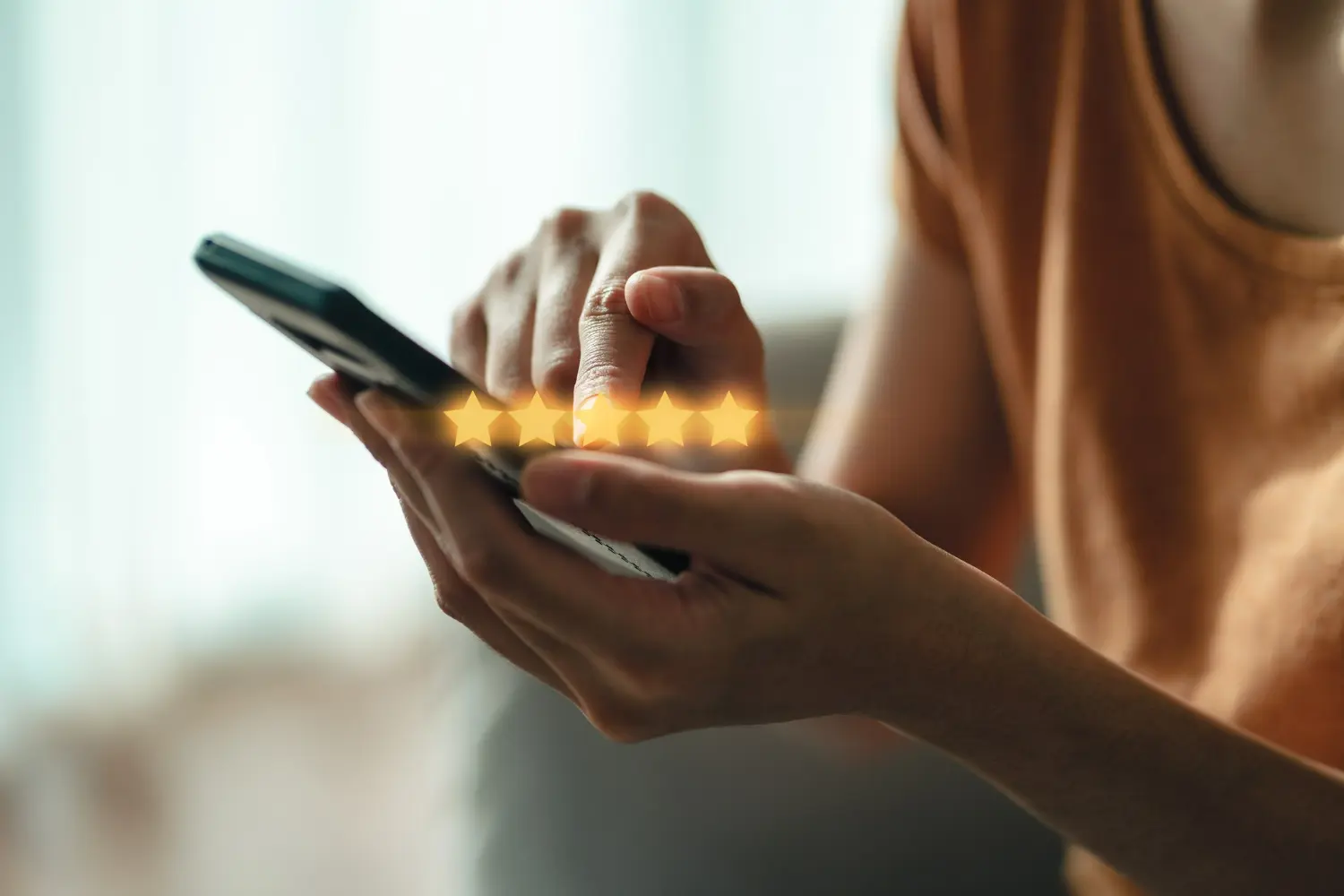 Close-up of a person using a smartphone to give a five-star rating, symbolizing online reviews, customer feedback, and reputation management