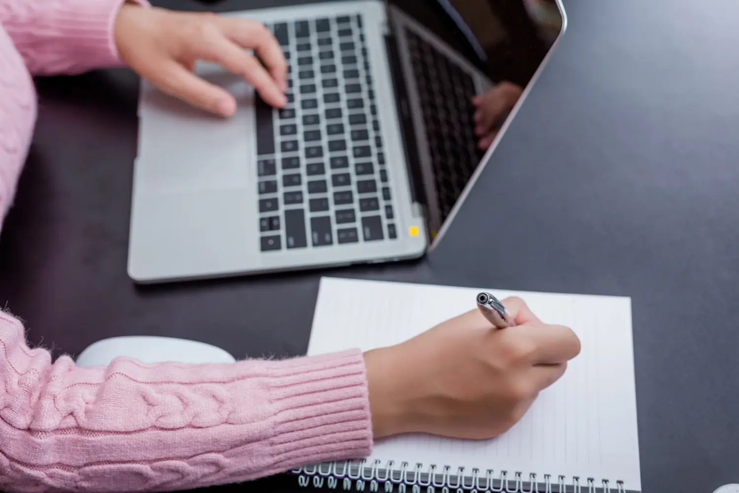 Marketer taking notes while working on a digital marketing content