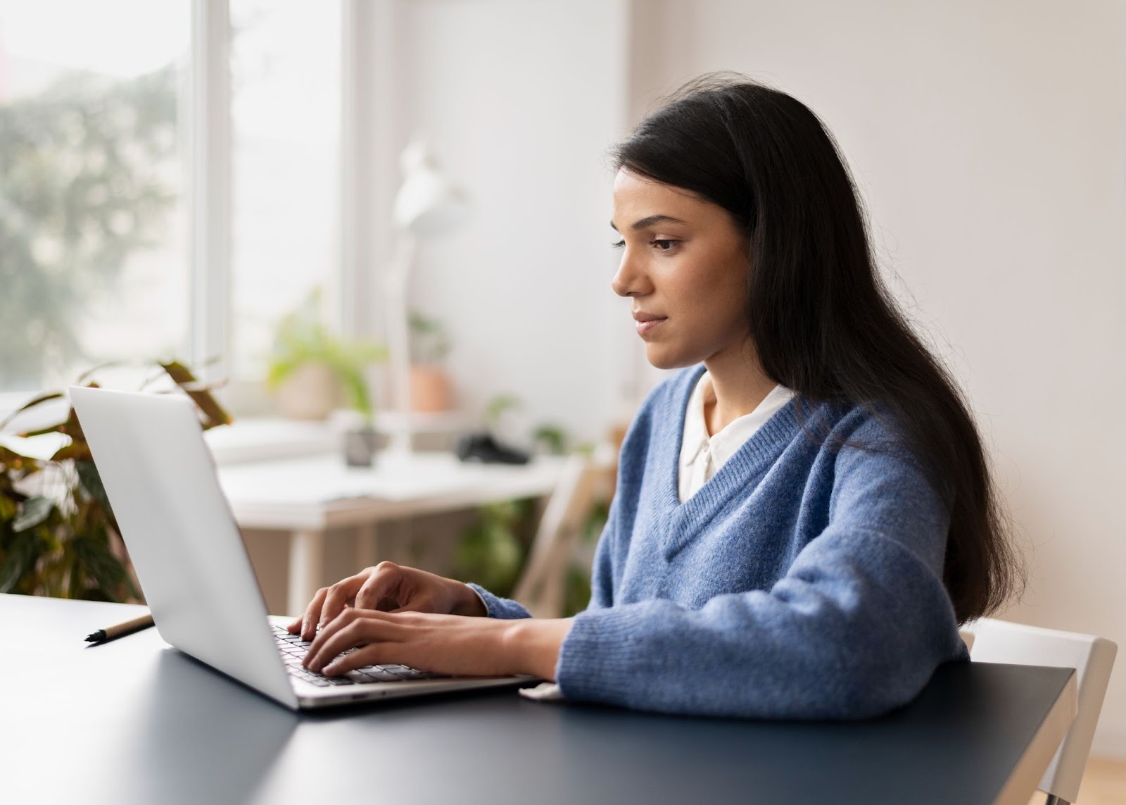 A woman in an office and using a laptop
