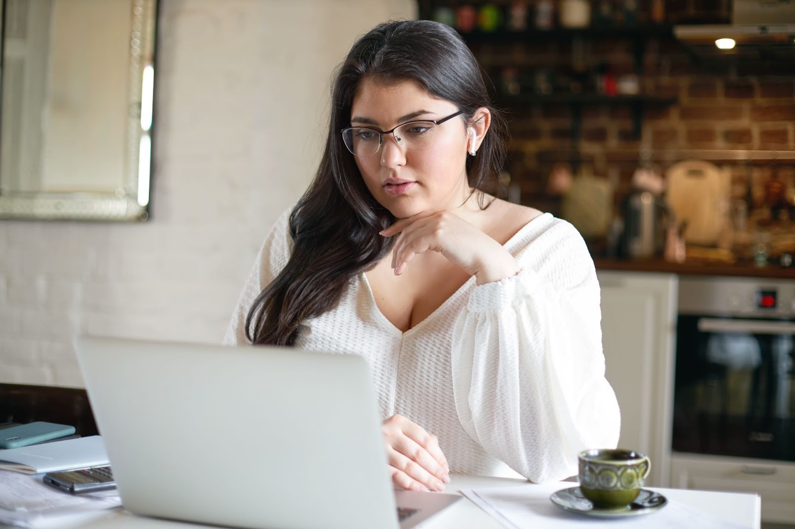 A woman working on a laptop and researching the difference between hiring professionals or doing a DIY approach in marketing addiction treatment centers