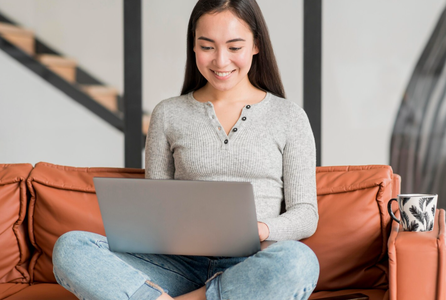 A woman and a potential rehab center lead comfortably seated on a couch, searching for the right facility