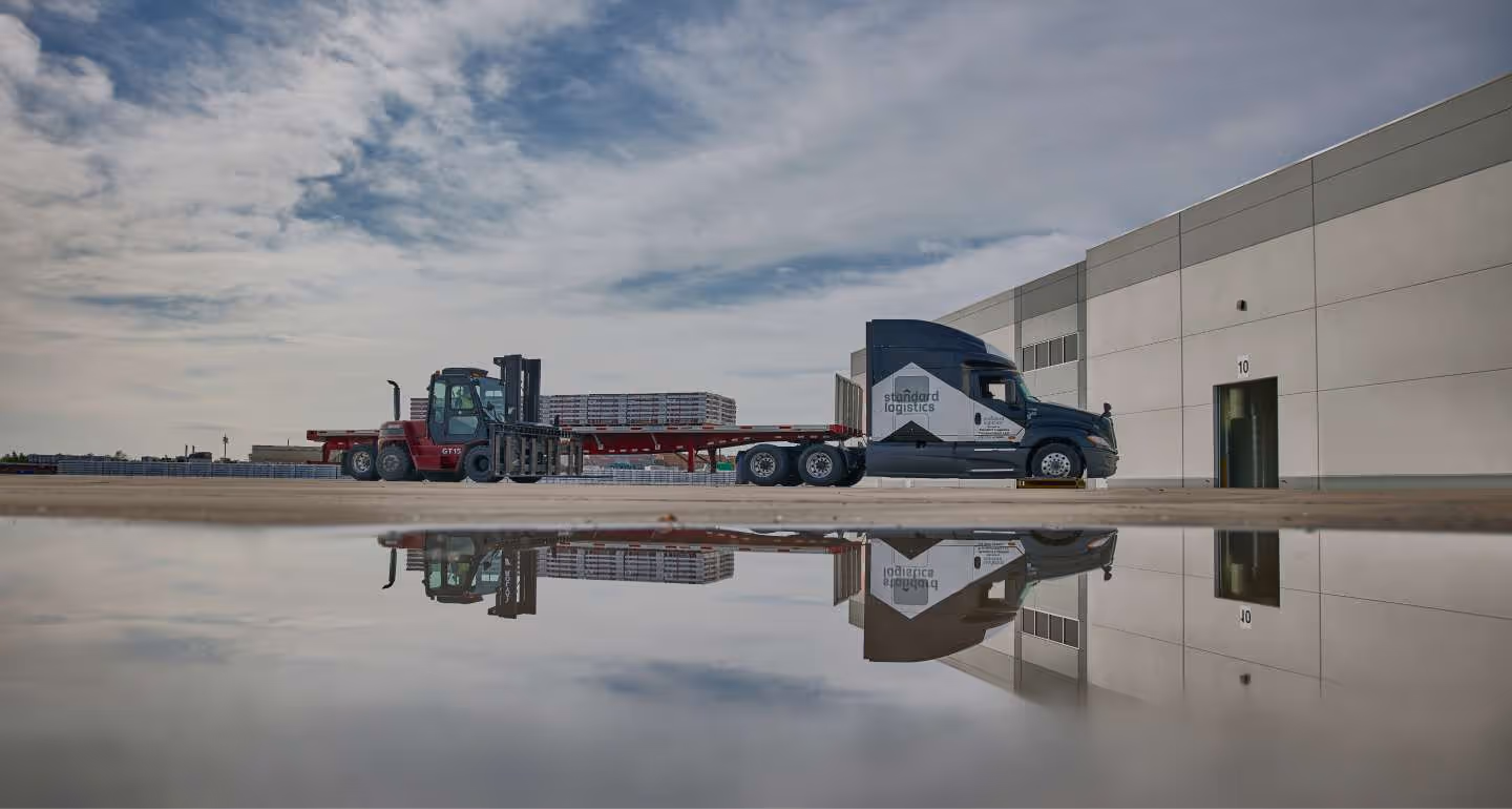 A large Standards Logistics truck outside a factory.