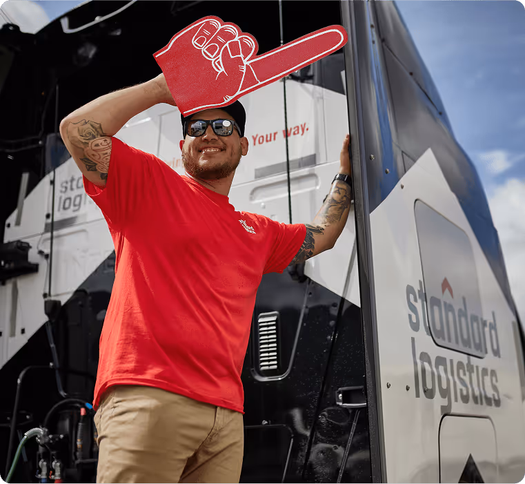 Driver smiling outside of a Standard Logistics truck.
