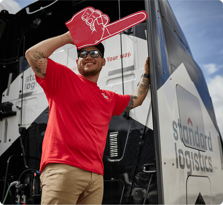 Driver smiling outside of a Standard Logistics truck.