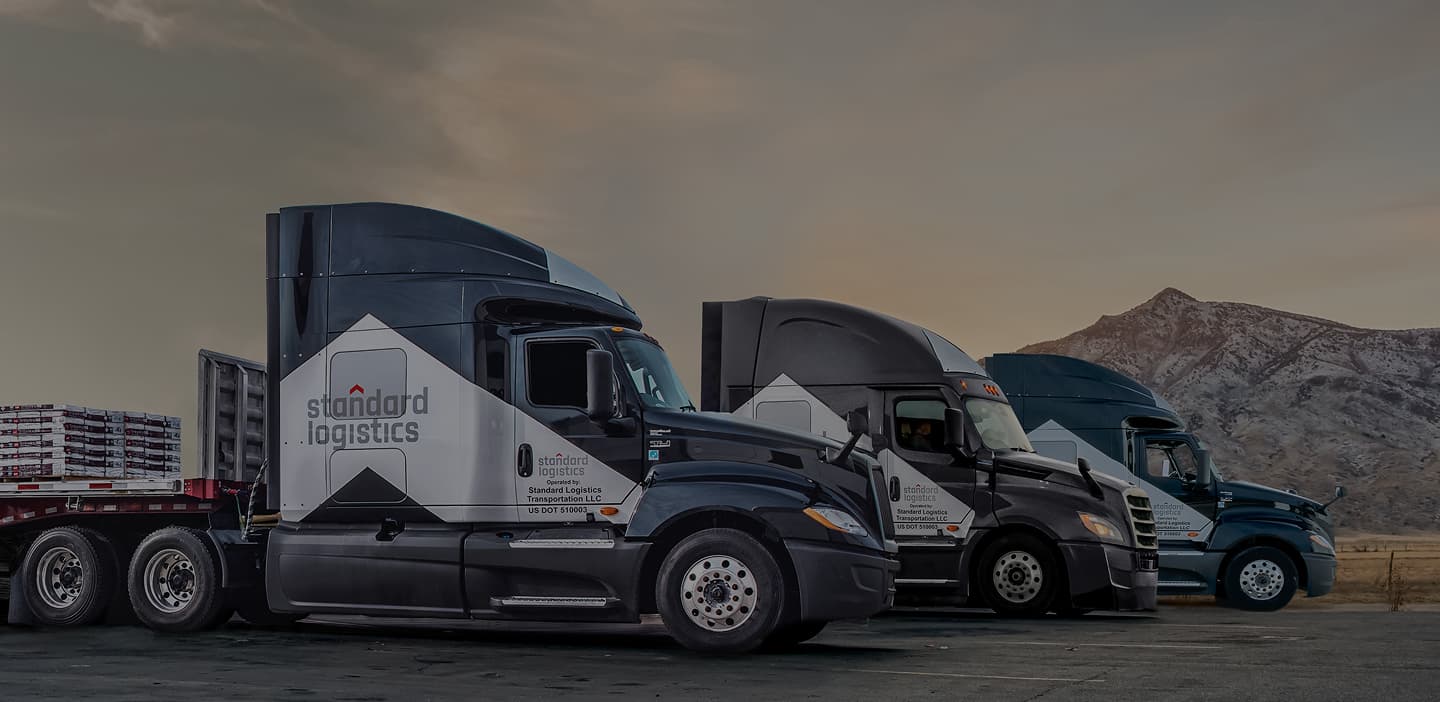 Three Standard Logistics trucks lined up.