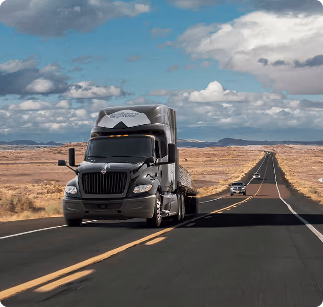 A Standard Logistics truck on a long highway in the desert. 
