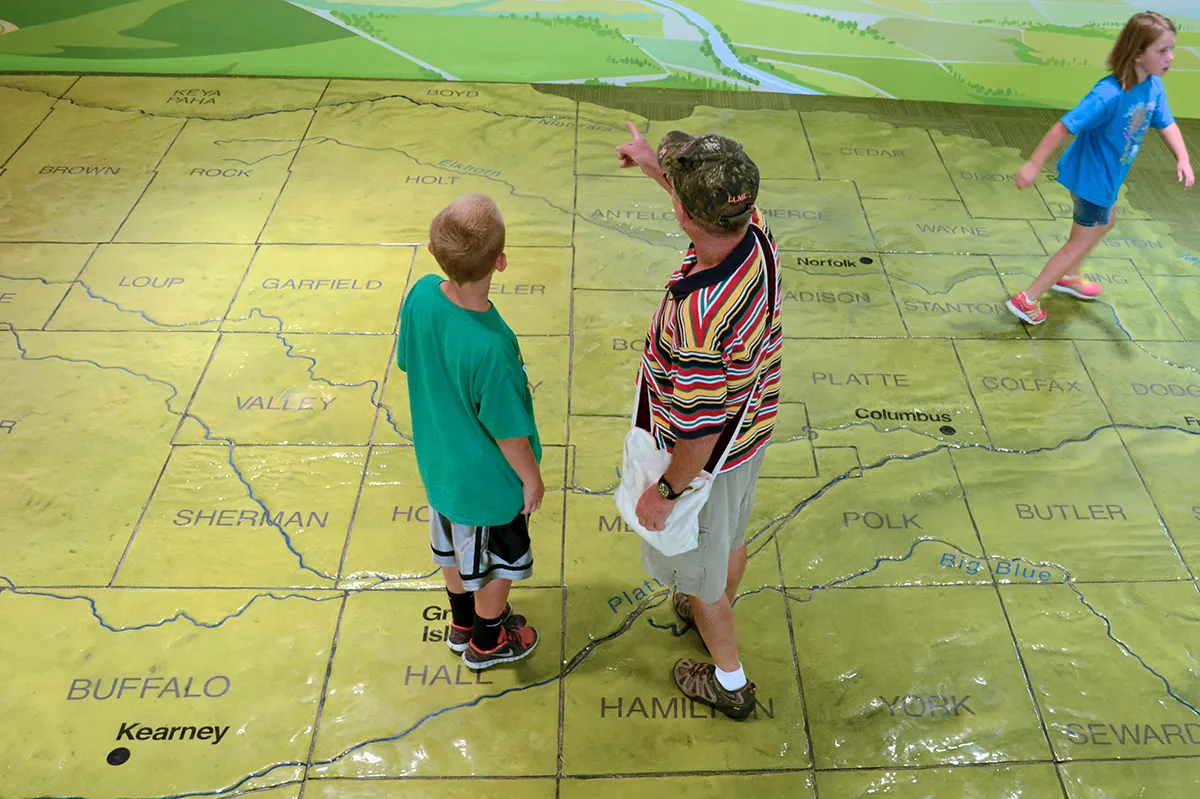 A father points out map information to his son at Raising Nebraska.