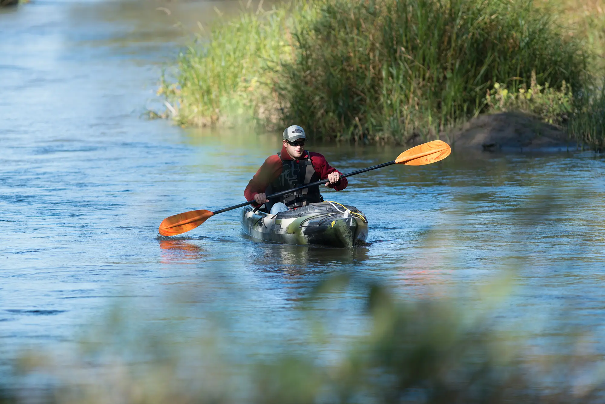 A kayaker floating down the Platte River through Mormon Island State Recreation Area.
