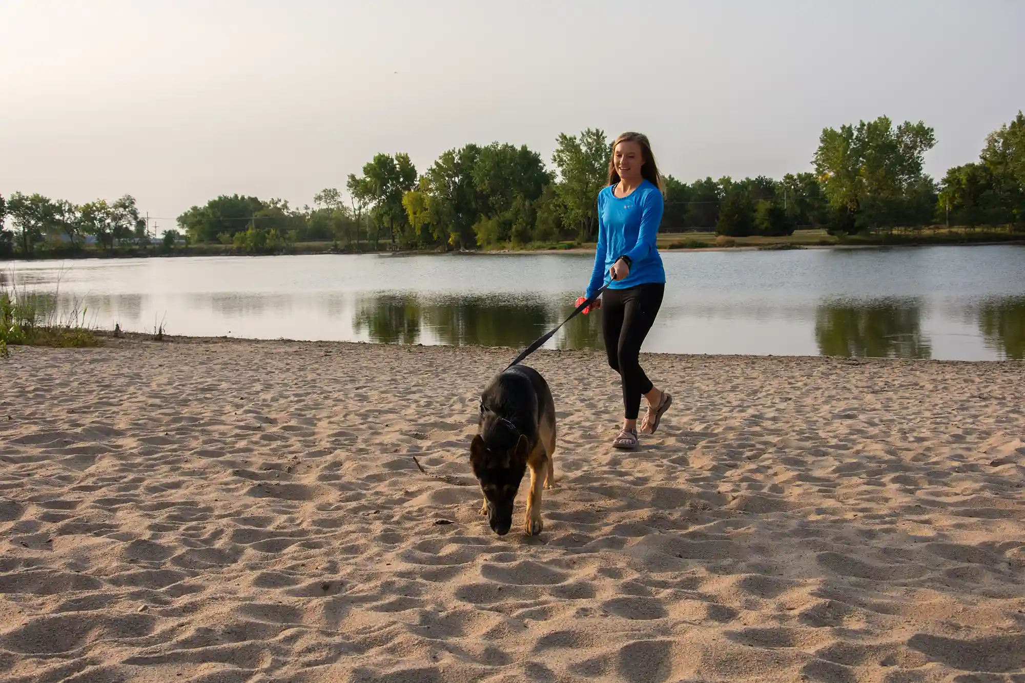 A young woman walks her German Shepherd puppy at L.E. Ray Lake in Grand Island.