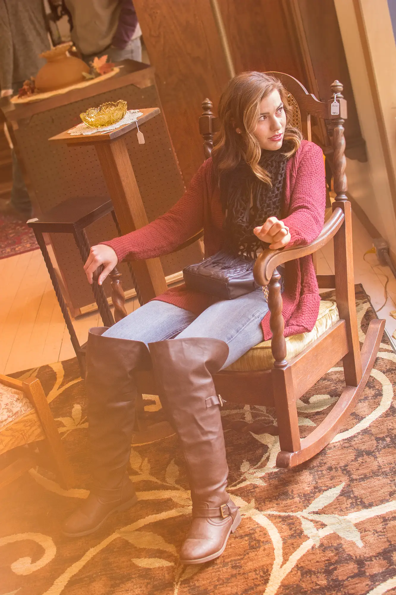 A young woman sits in an antique chair while shopping at boutiques in Grand Island, Nebraska's, historic Railside district.