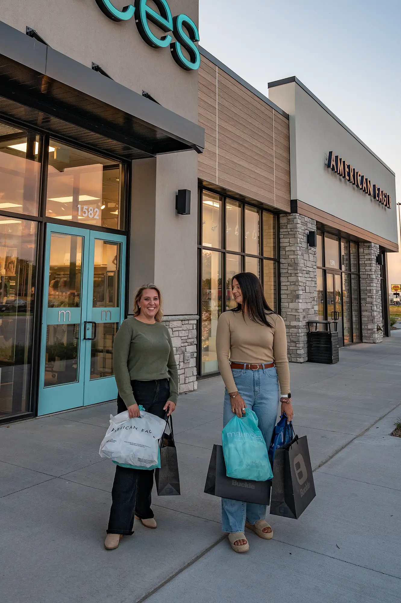 Two women carry bags of clothing they purchased at the Conestoga Marketplace in Grand Island, Nebraska. 