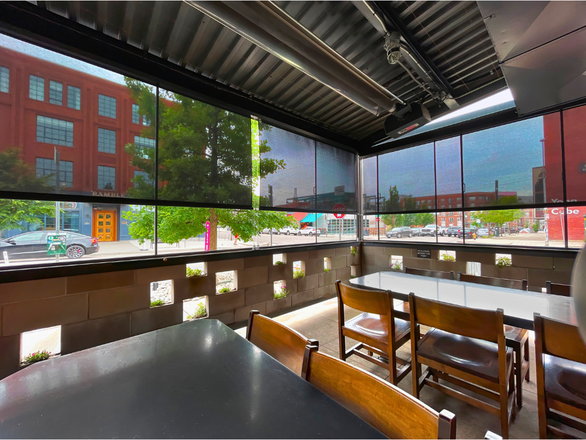 Outdoor dining area with solar shades and metal roof