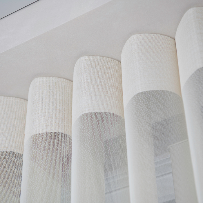 Close-up of sheer vertical blinds with clean curved folds hung from a ceiling track