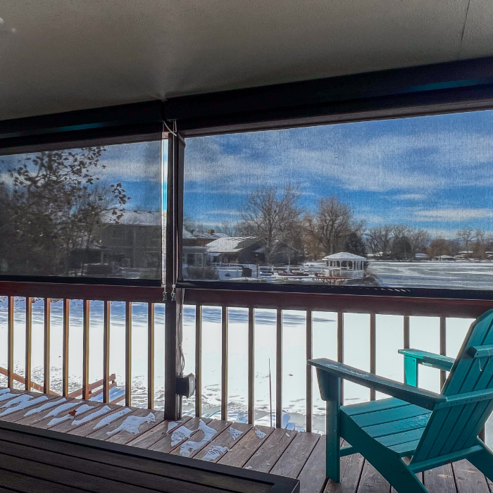 Winter view through clear vinyl roll-down shades on covered porch