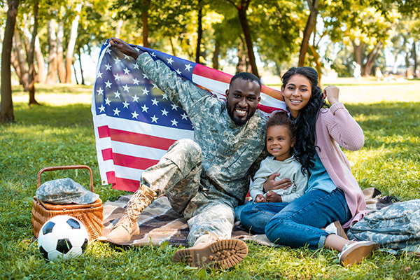 Military family on a picnic holding an American flag