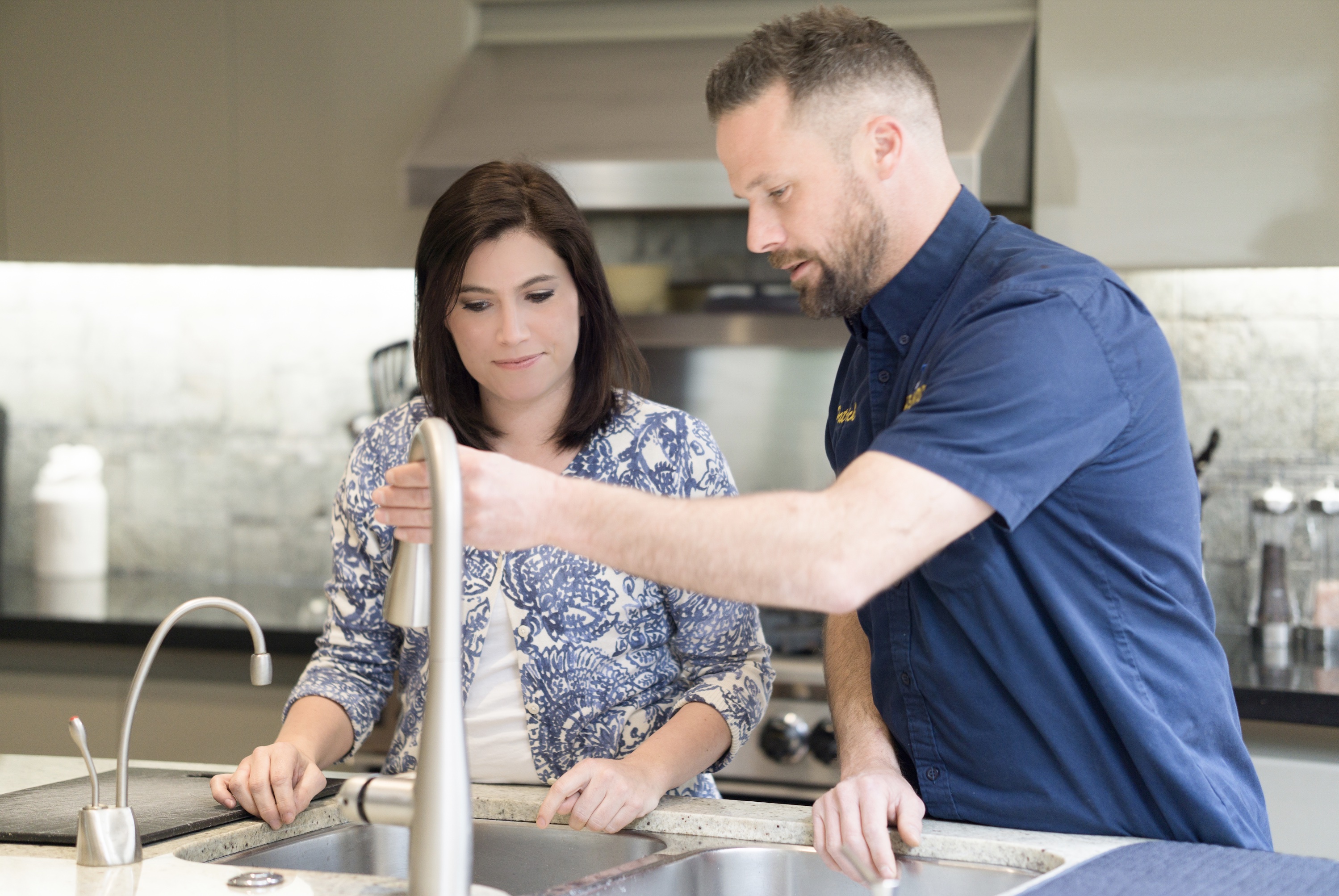 image of plumber working under a sink