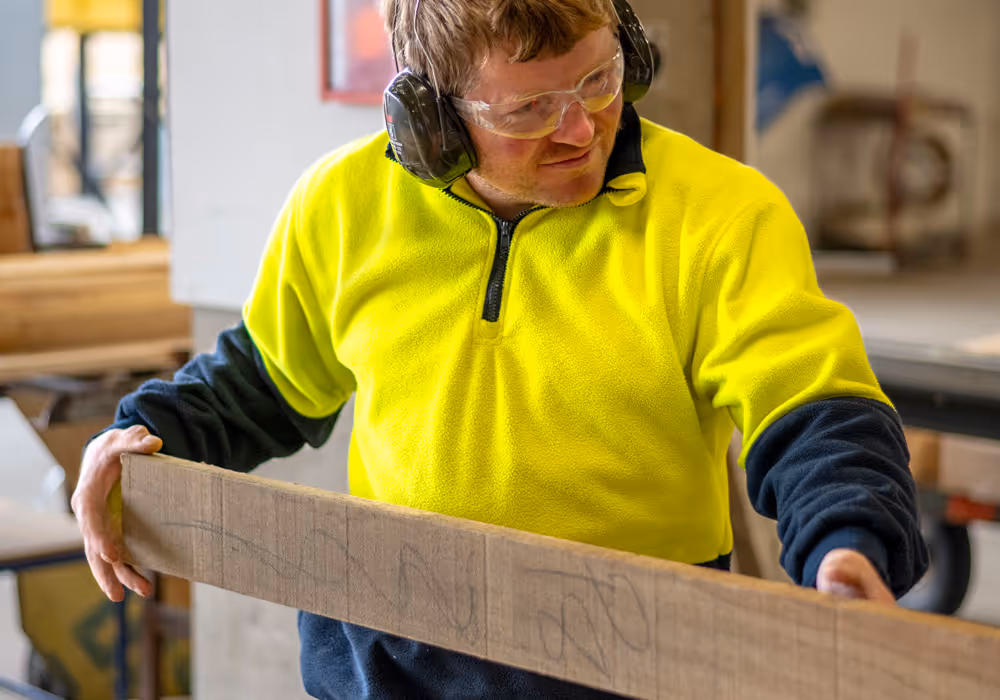 Photo of a team member from the timberworks department cutting a plank of timber