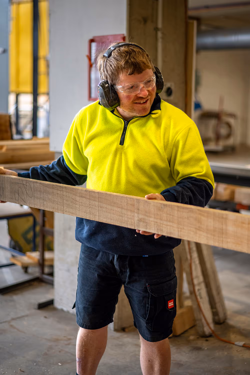 Photo of a team member from the timberworks department cutting a plank of timber