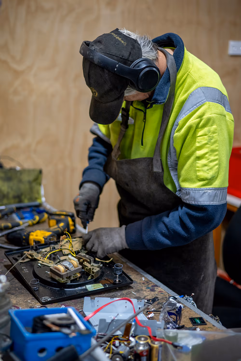A photo of an e-waste recycling team member taking apart an electrical item