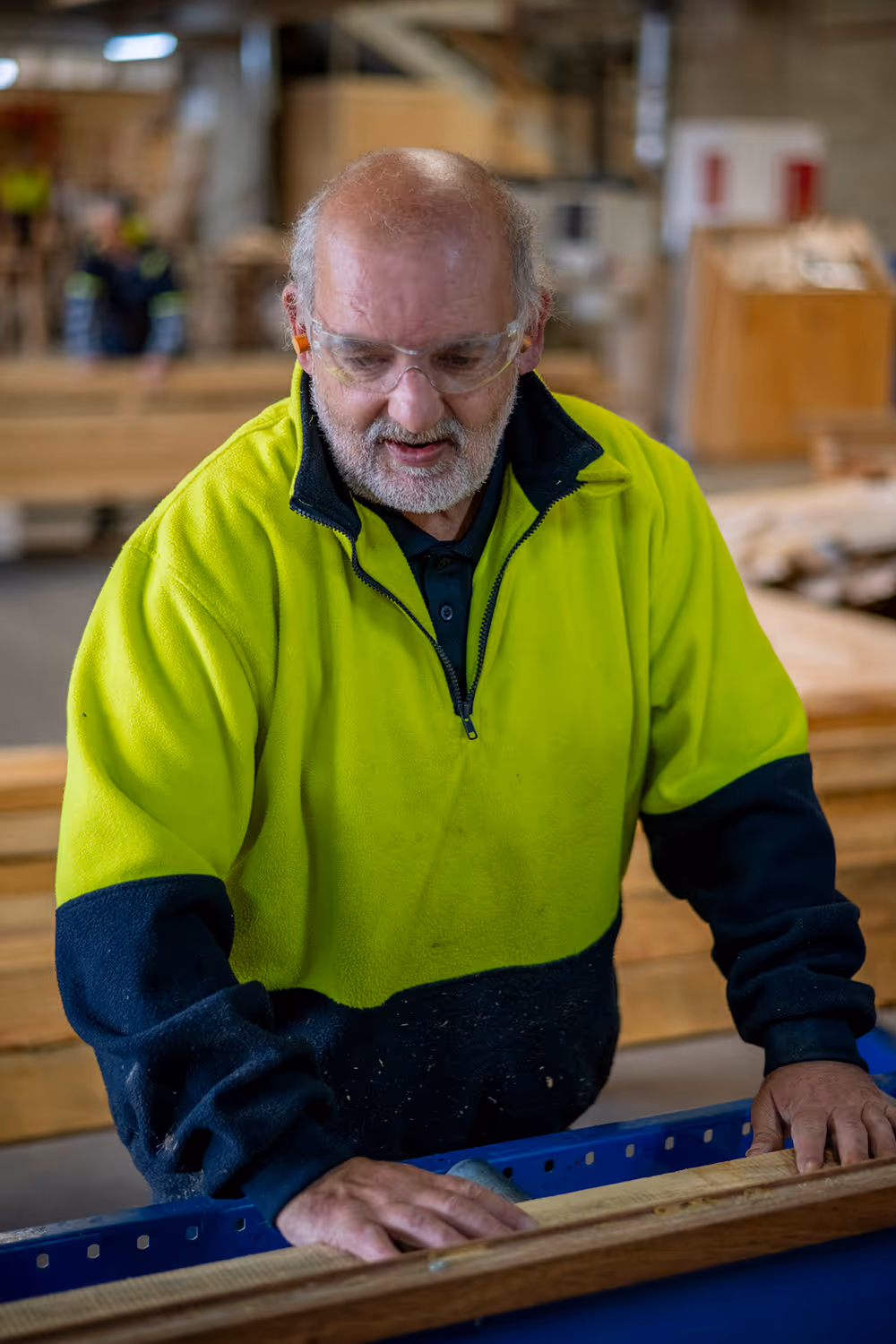 A photo of a timberworks team member looking at timber planks