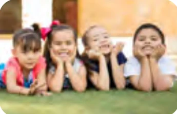 Smiling preschool children lying on the grass
