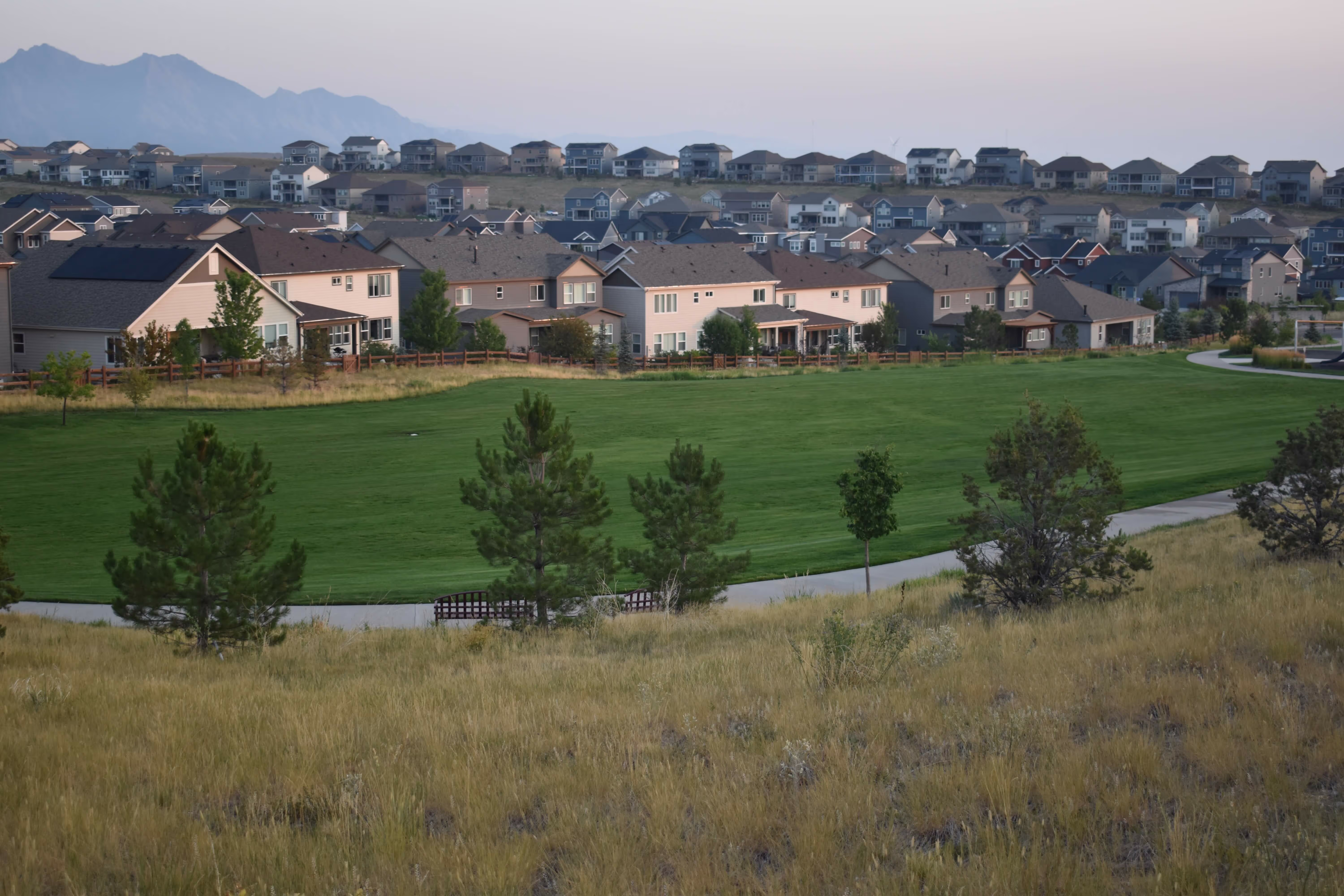In the distance, a perfectly trimmed grass field sits behind a quiet residential neighborhood. 
