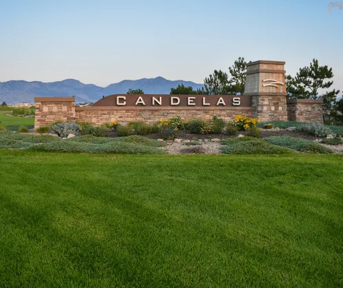 A field of perfectly trimmed grass surrounds an entrance sign under the crack of dawn.