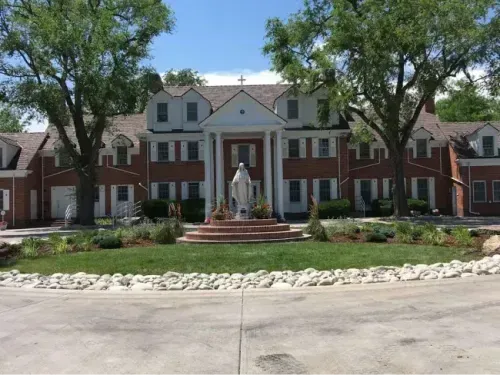 At the front entrance of a building, neatly trimmed grass and well-maintained trees create a welcoming and polished landscape.