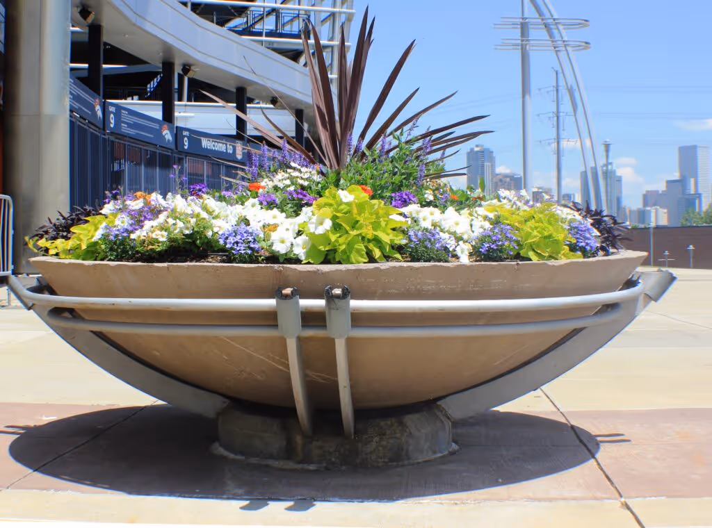 A large planter filled with a bouquet of colorful flowers on an elevated floor at Empower Field at Mile High. 