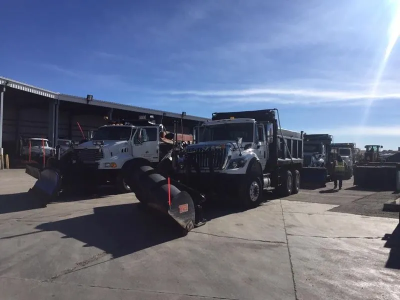 A convoy of work trucks prepares to set off, ready to drive off for the day’s assignments.