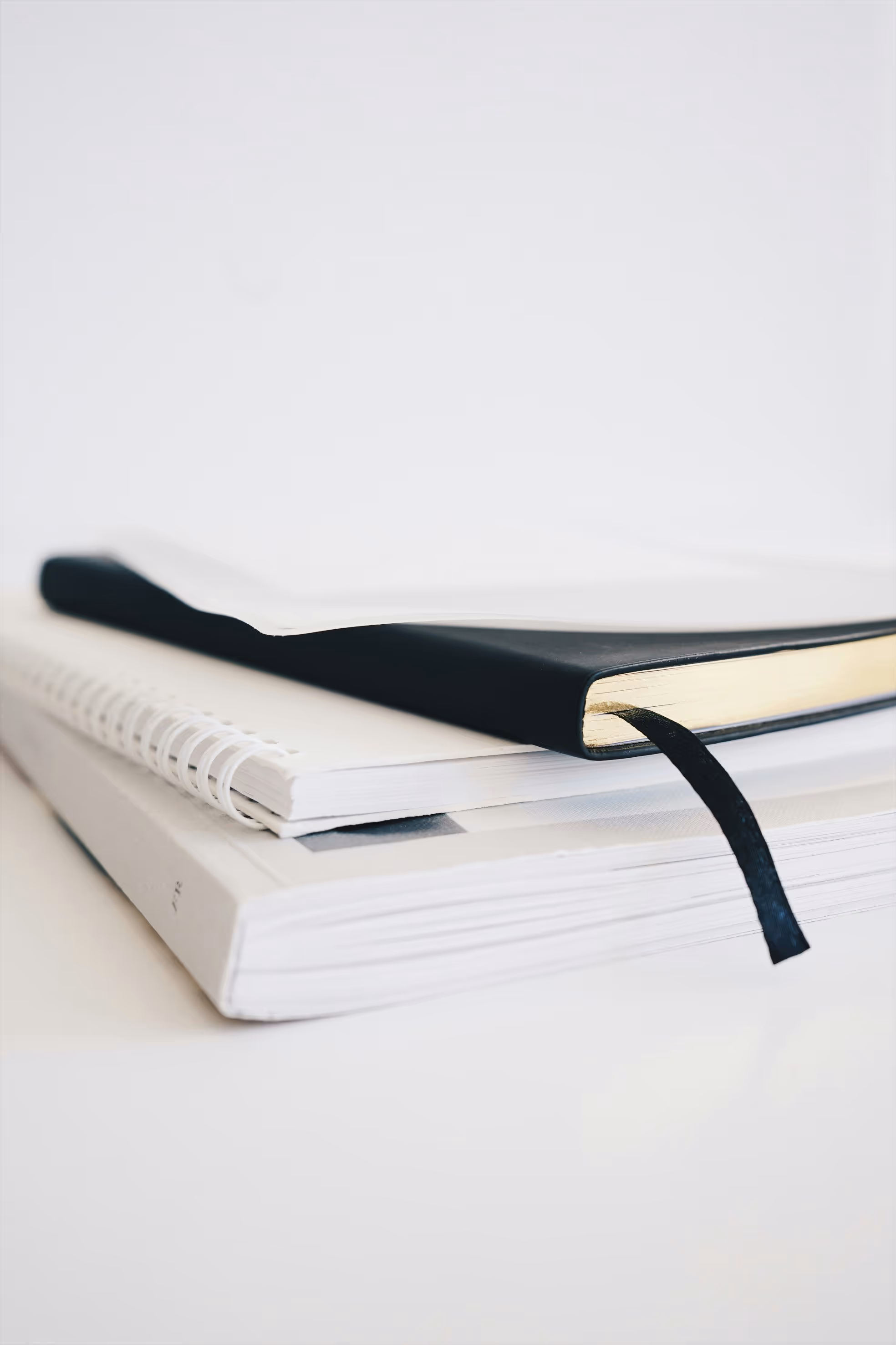 a hardcover, spiral and paperback book stack