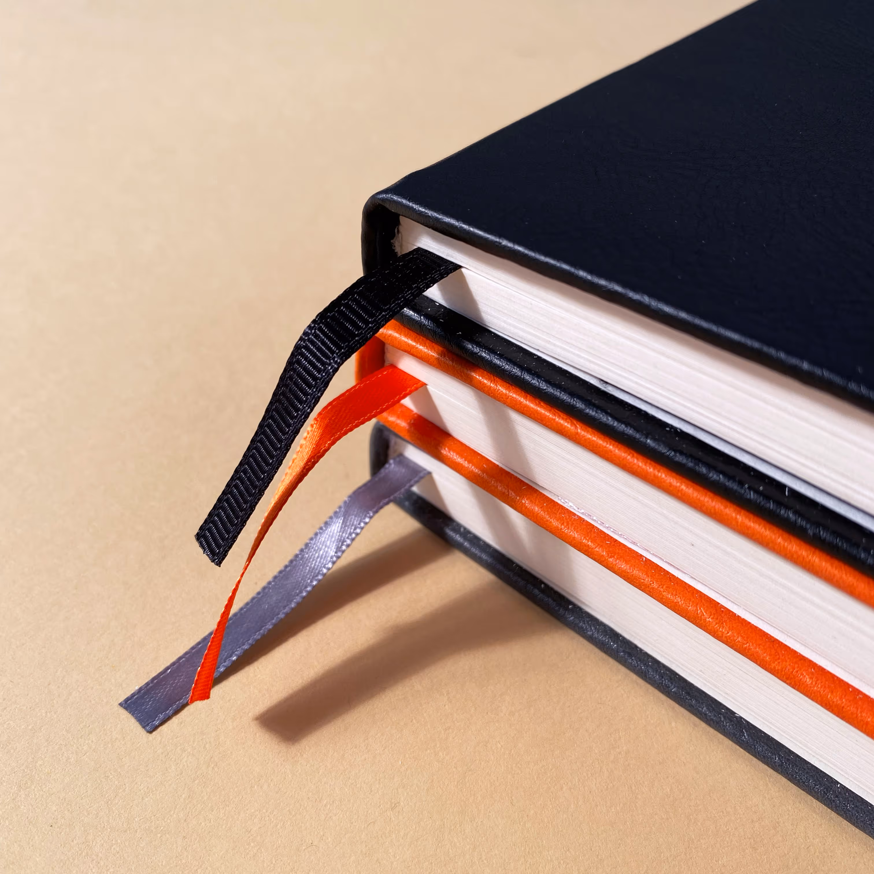 stack of hardcover notebooks with ribbon sticking out