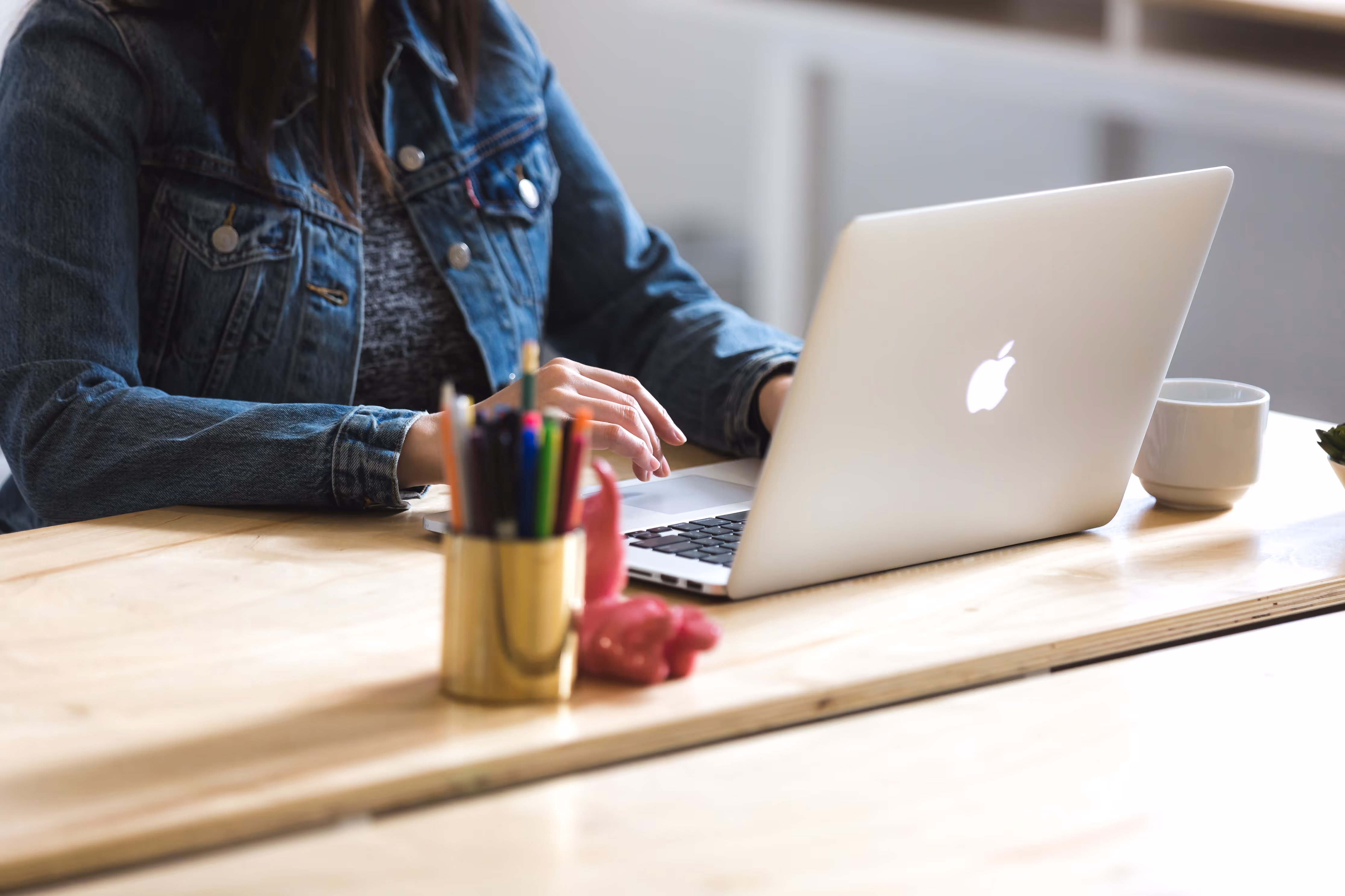 woman working on a macbook at a table