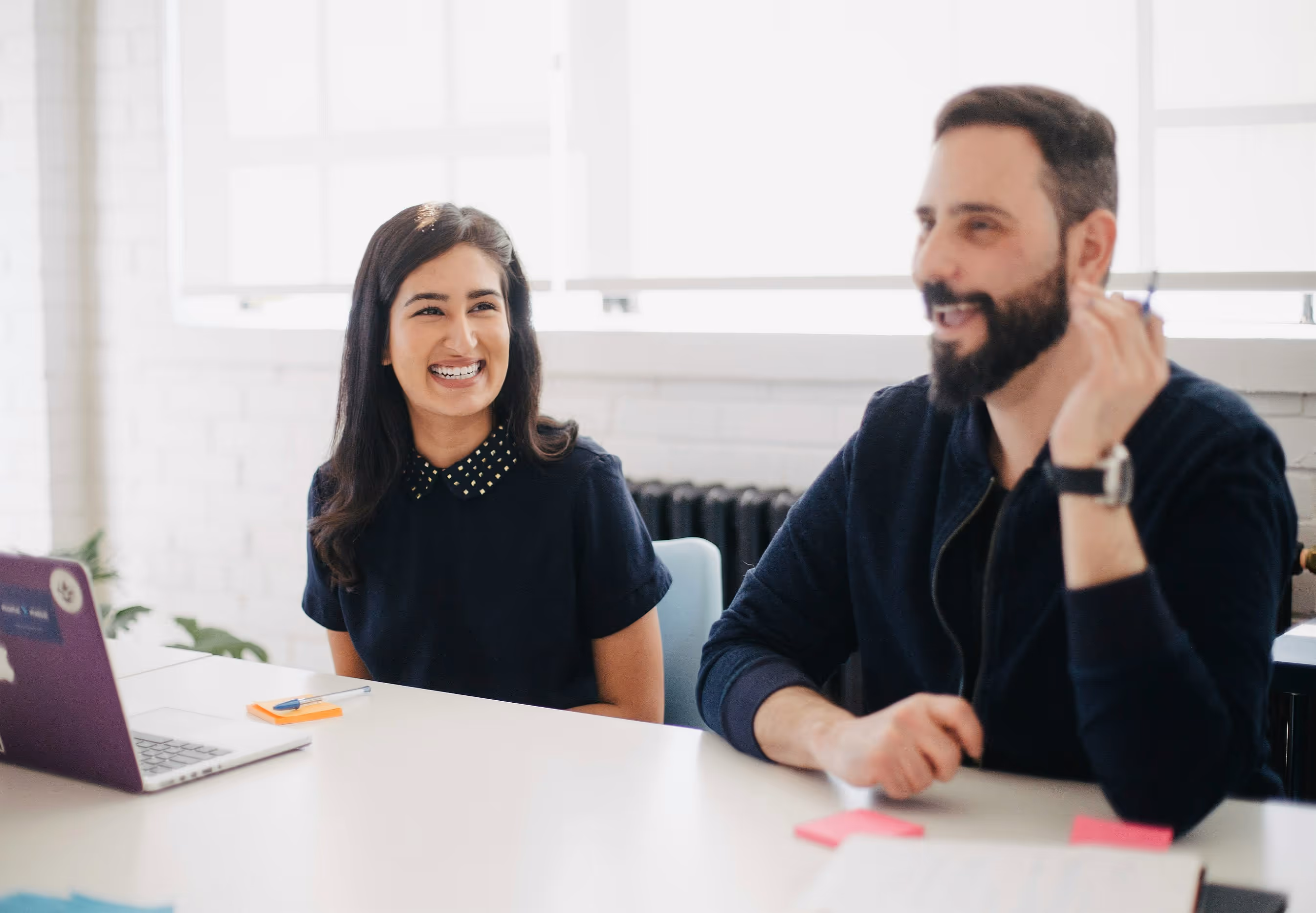 a man and a woman smiling in a meeting
