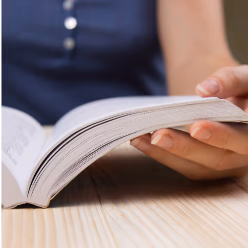person wearing a navy top holding an open book