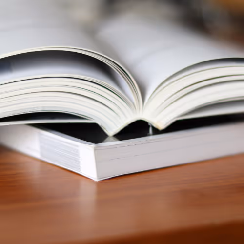 an open paperback lying on a closed paperback book