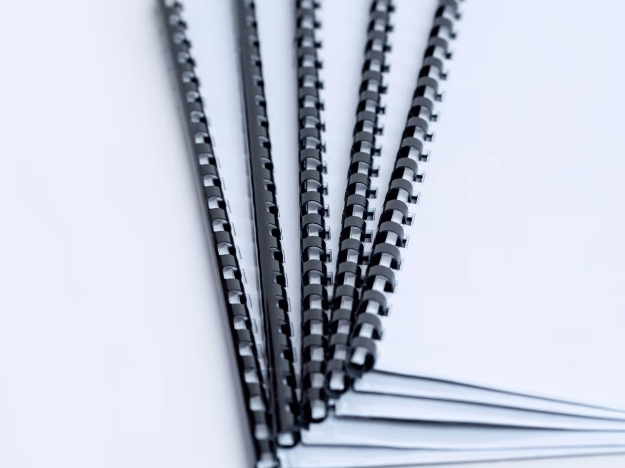 four stacked comb bound manuals or reports