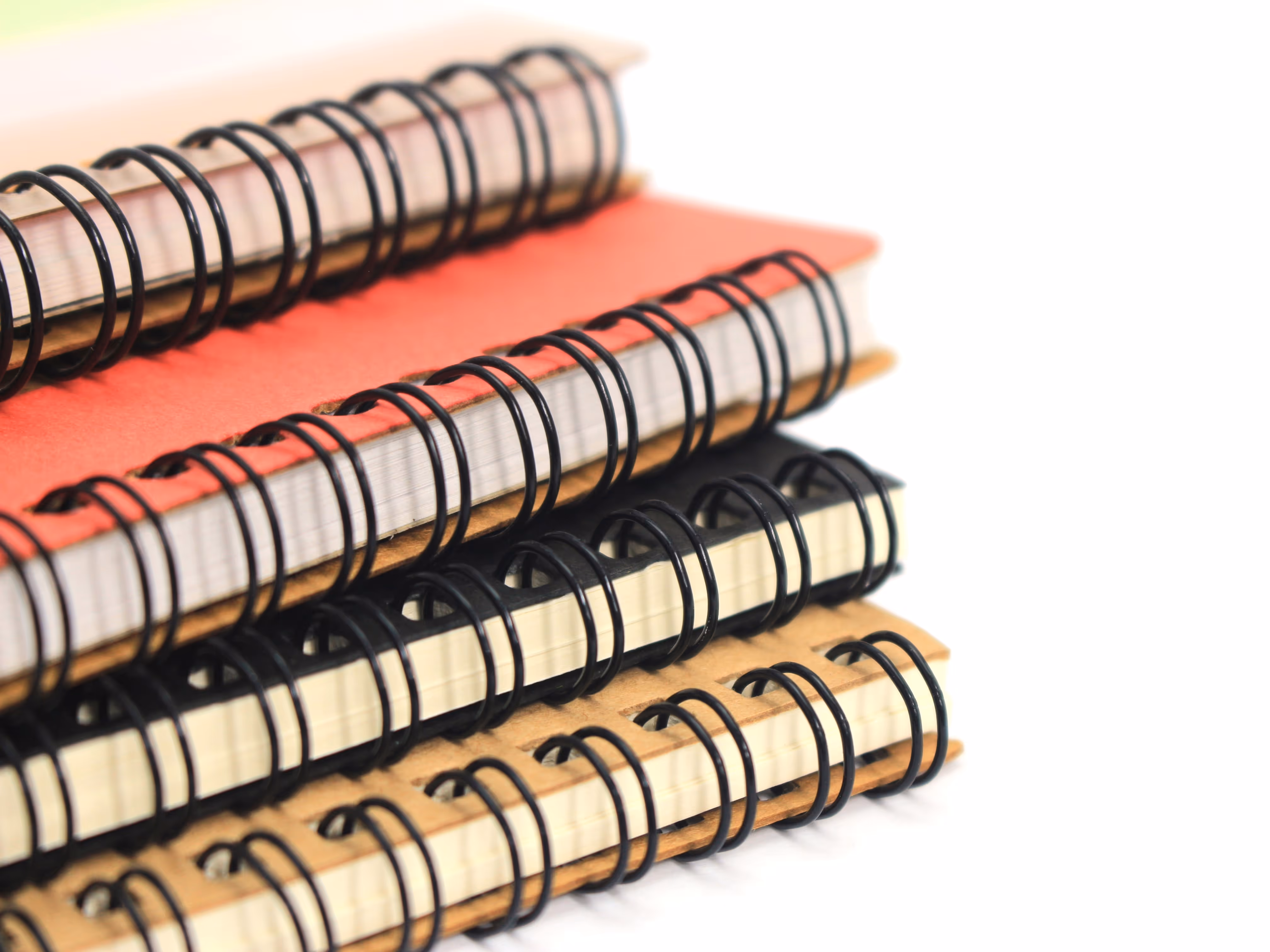 four different coloured wirebound notebooks