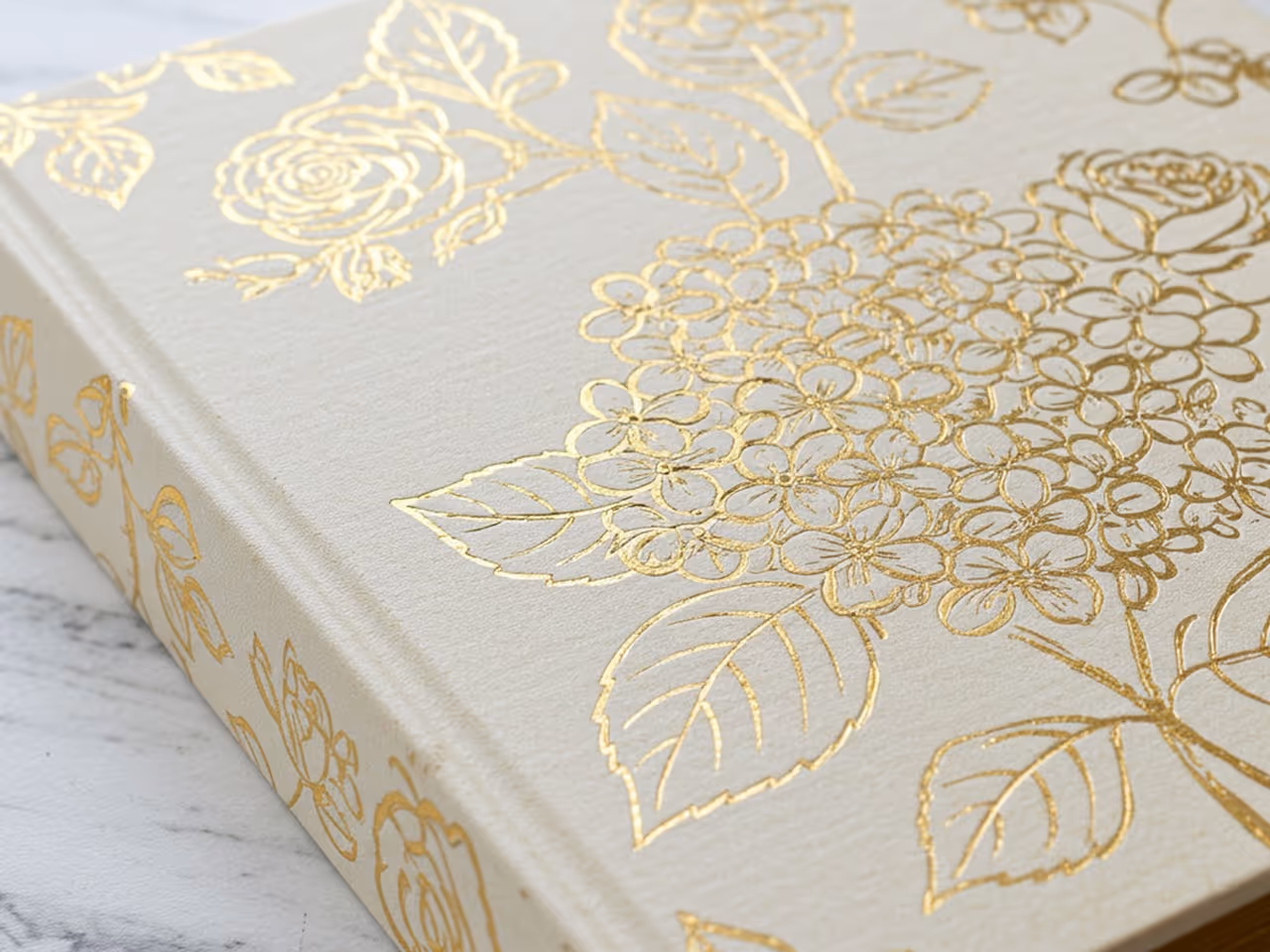a floral pattern foil stamped on a beige hardcover book