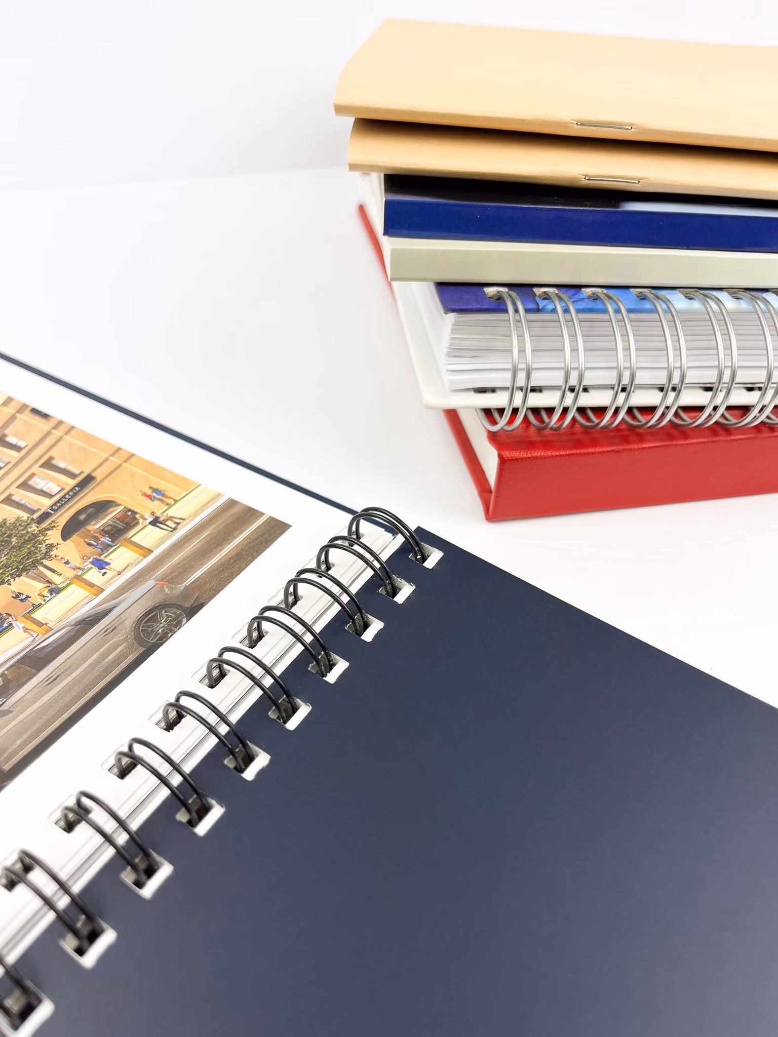 stack of books with different binding and an open wire-o bound book
