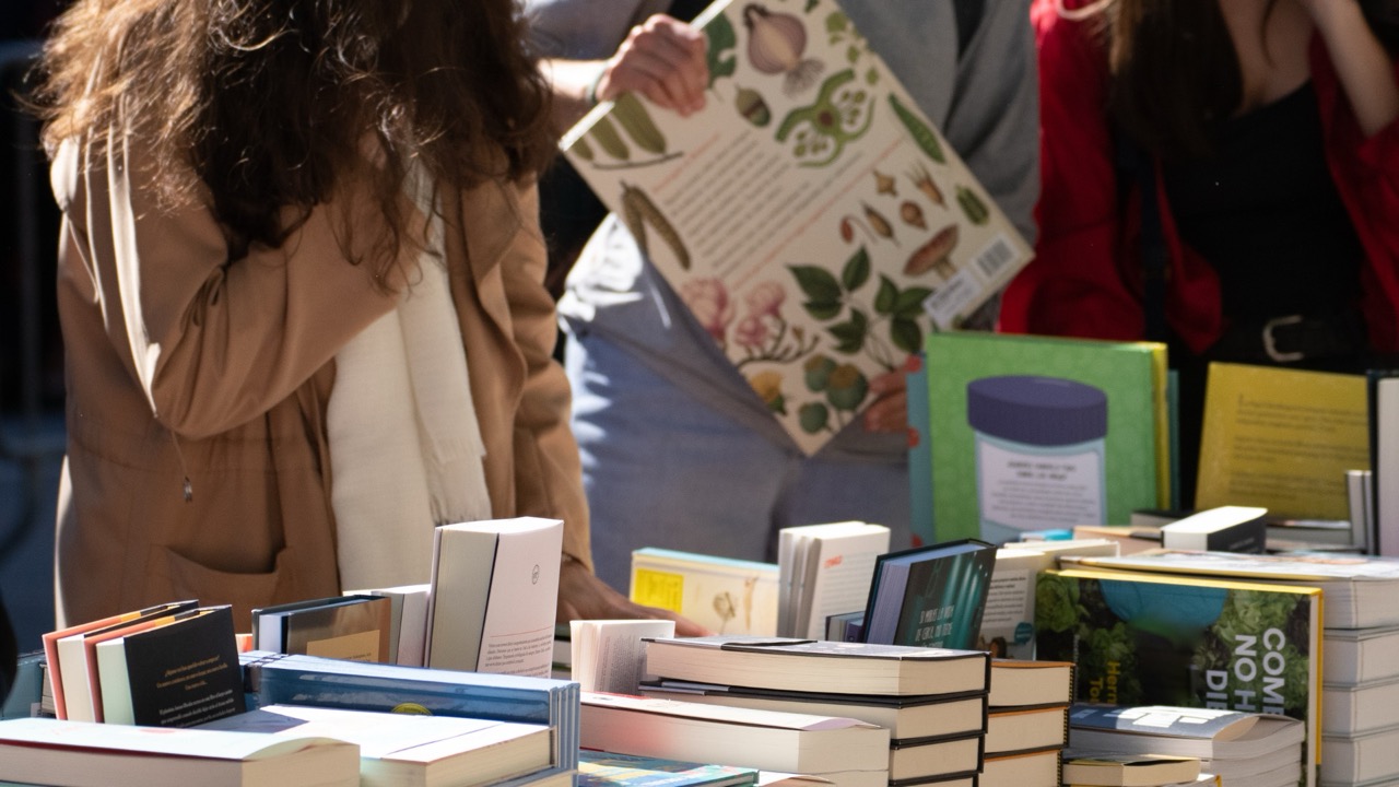 people browsing books to buy at a market