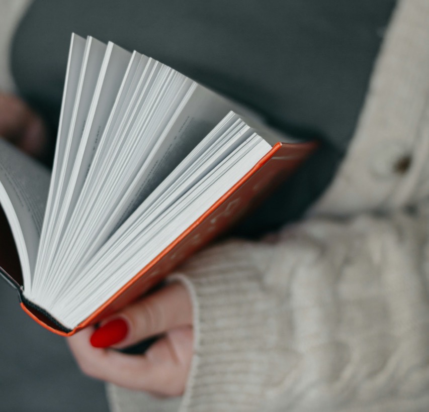 Woman holding open a book. Photo by Svitlana Rusak on Unsplash